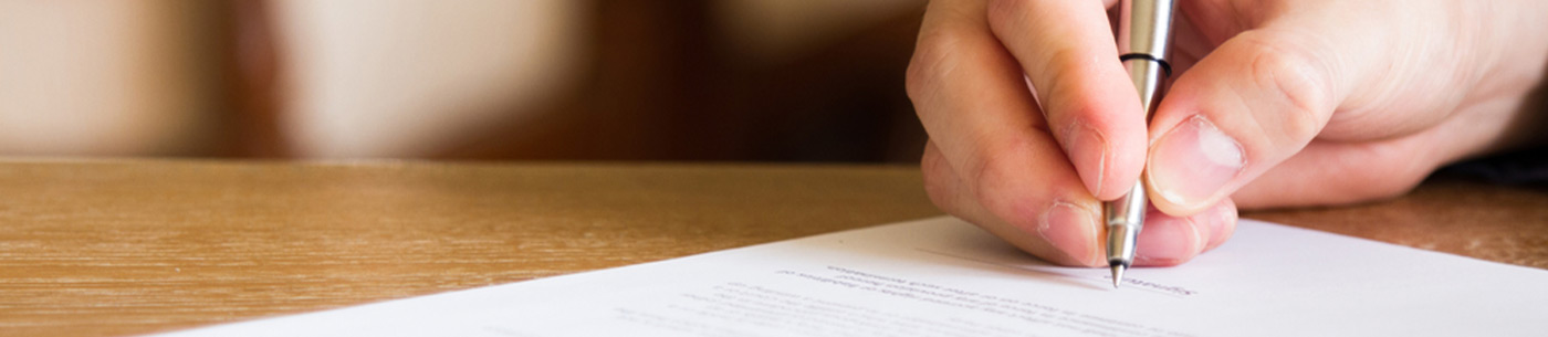 pen in hand signing document